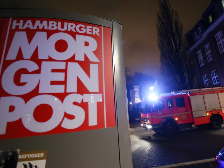 Einsatzkräfte der Feuerwehr stehen am 11.01.2015 vor dem Gebäude der «Hamburger Morgenpost» in Hamburg.
