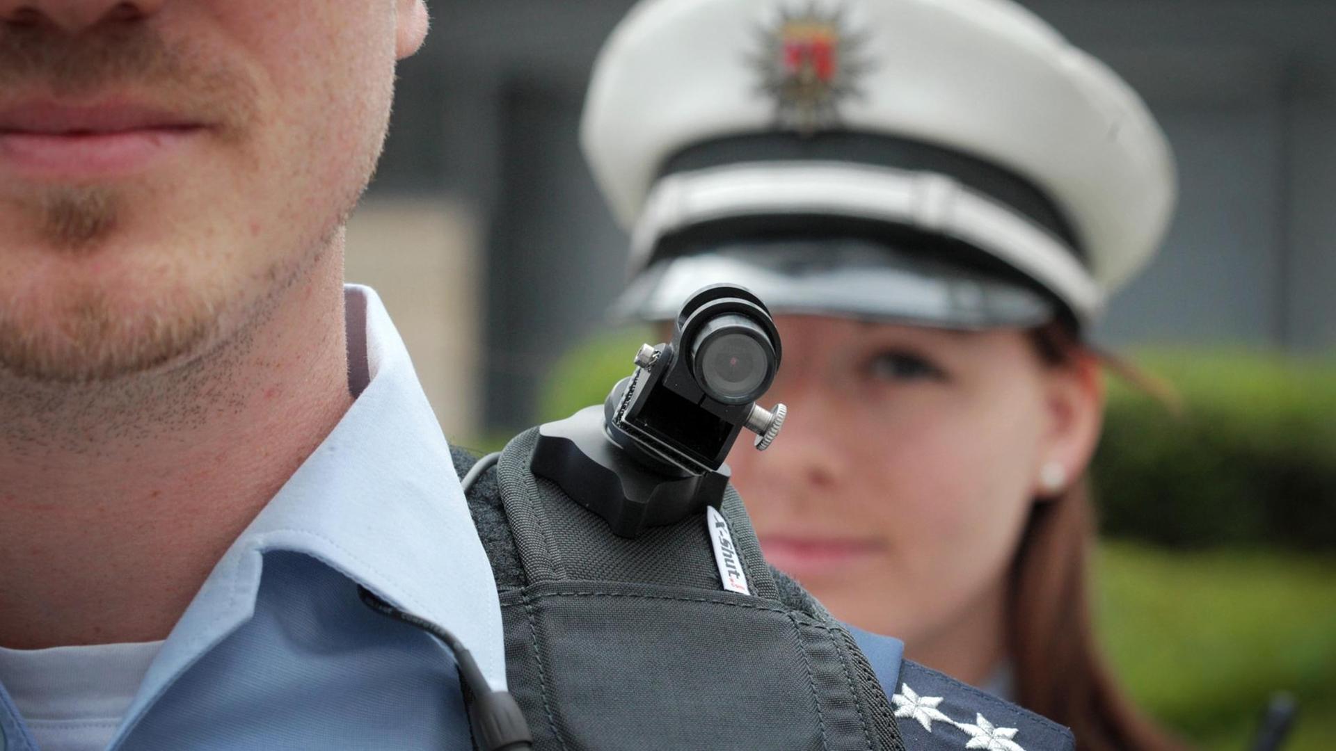Ein Polizist trägt eine mobile Miniatur-Videokamera auf seiner Schulter.