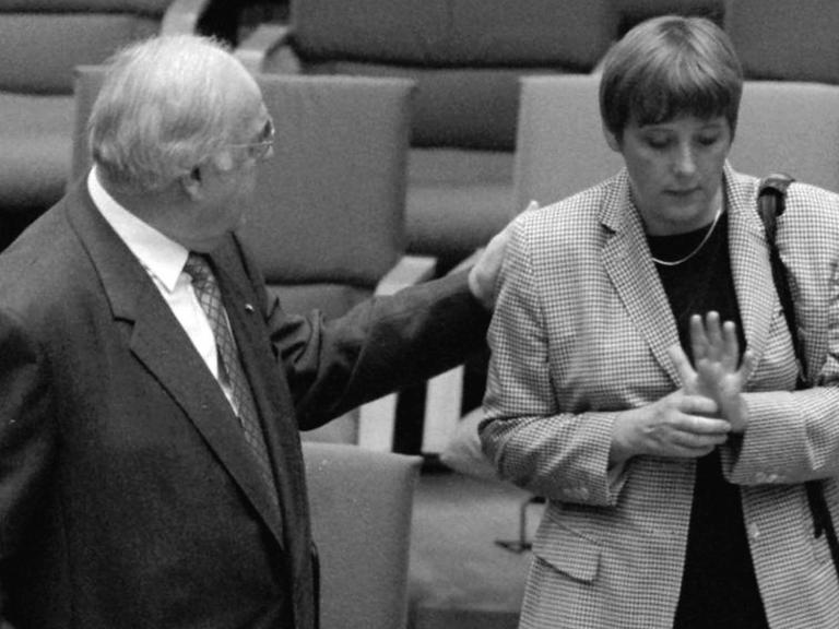 Undatiertes Foto vom damaligen Bundeskanzler Helmut Kohl wie er die damalige Bundesumweltministerin Angela Merkel im Bonner Bundestag auf die Schulterklopft.