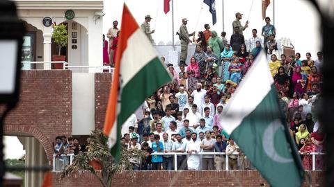 Feierlichkeiten an der Indisch-Pakistanischen Grenze in Wagah - einem Grenzübergang an der Straße zwischen Amritsar, Punjab (Indien) und Lahore, Punjab (Pakistan) sowie Teil der Grand Trunk Road. Es ist der einzige Grenzübergang in den genannten Bundesstaaten zwischen Indien und Pakistan. Im Vordergrund sind die Flaggen Indiens und Pakistans zu sehen.