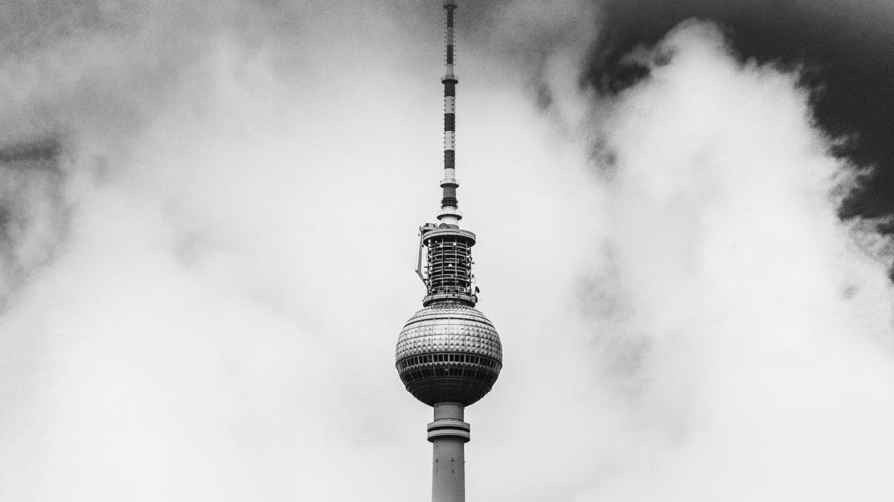 Der Berliner Fernssehturm ist zwischen Wolken zu sehen.