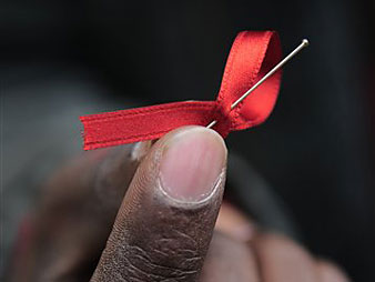 Ein Afrikaner zeigt im spanischen Pamplona die rote AIDS-Schleife.