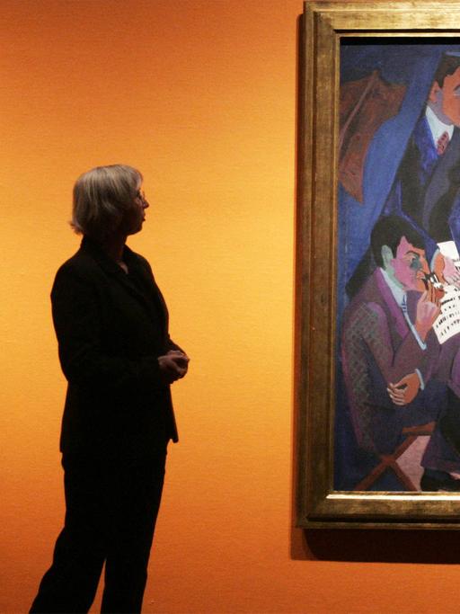 Eine Frau betrachtet zwei Werke von Ernst Ludwig Kirchner: Ein Selbstporträt (links) und das Gemälde "Eine Künstlergruppe: Mueller, Kirchner, Heckel, Schmidt-Rotluff".