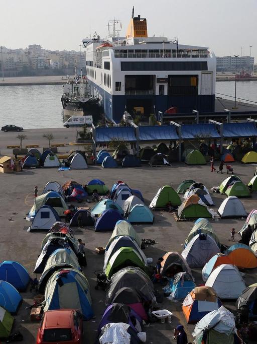 Sie sehen zahlreiche kleine Zelte am Hafen von Piräus.