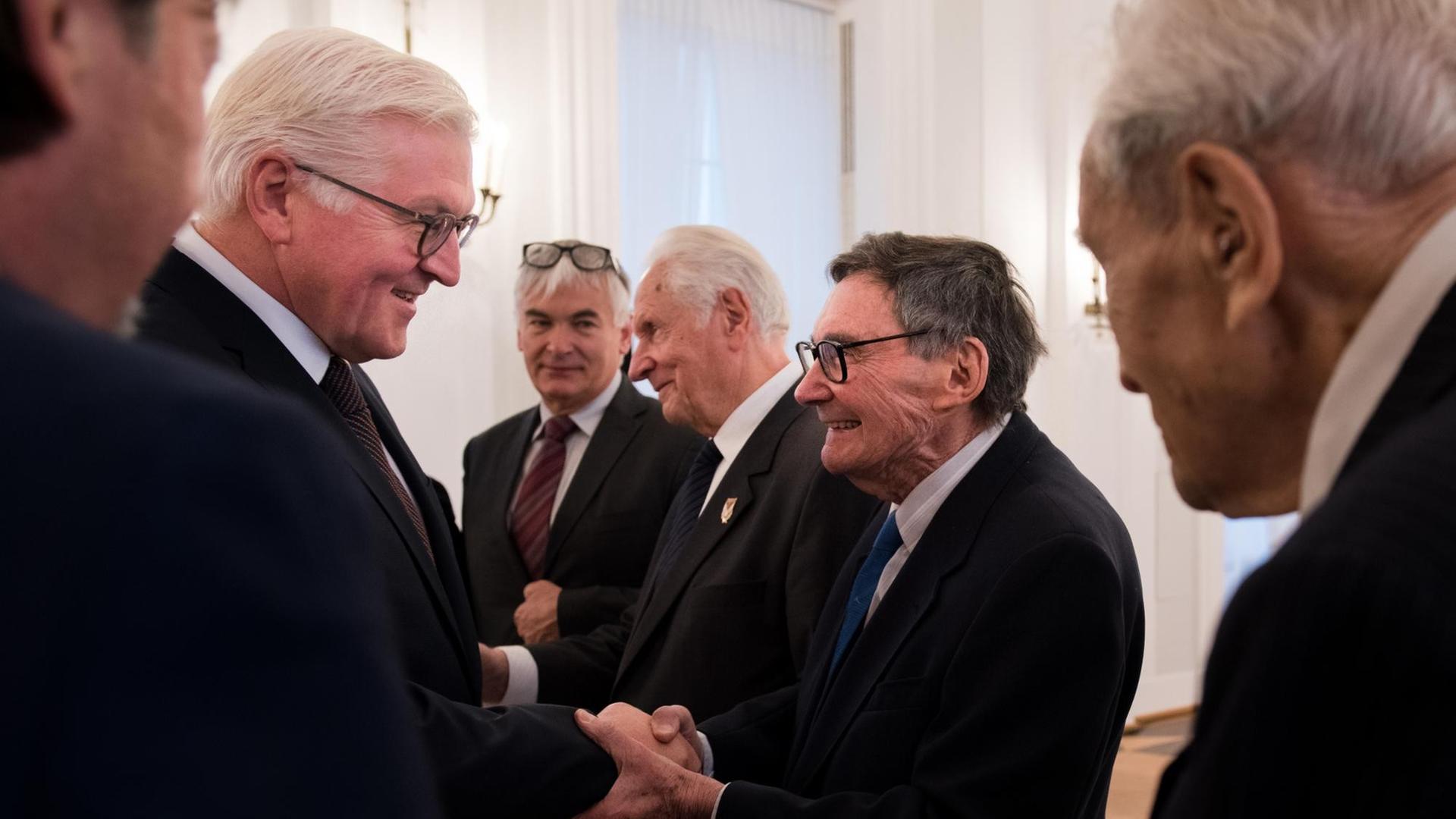 Bundespräsident Frank-Walter Steinmeier (l, SPD) begrüßt am 09.11.2017 den polnischen Journalisten Marian Turski und andere Vertreter des internationalen Auschwitz Komitees im Schloss Bellevue in Berlin.