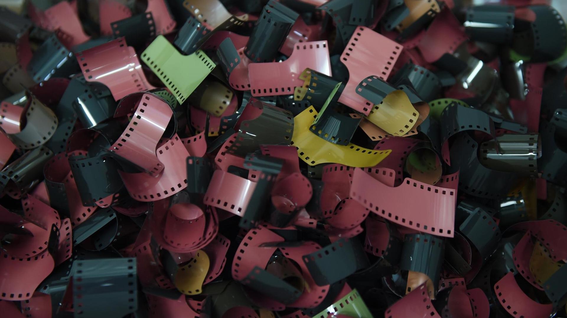 Filmrollen mit Negativen liegen in einer Schale.
