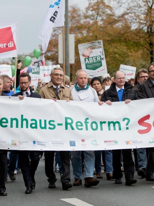 Geschäftsführer Mittelfränkischer Kliniken tragen am 23.09.2015 in Nürnberg (Bayern) einen Banner mit der Aufschrift "Krankenhaus-Reform? So nicht!". Mehrere hundert Klinikmitarbeiter protestierten gegen die bevorstehende Krankenhausreform.