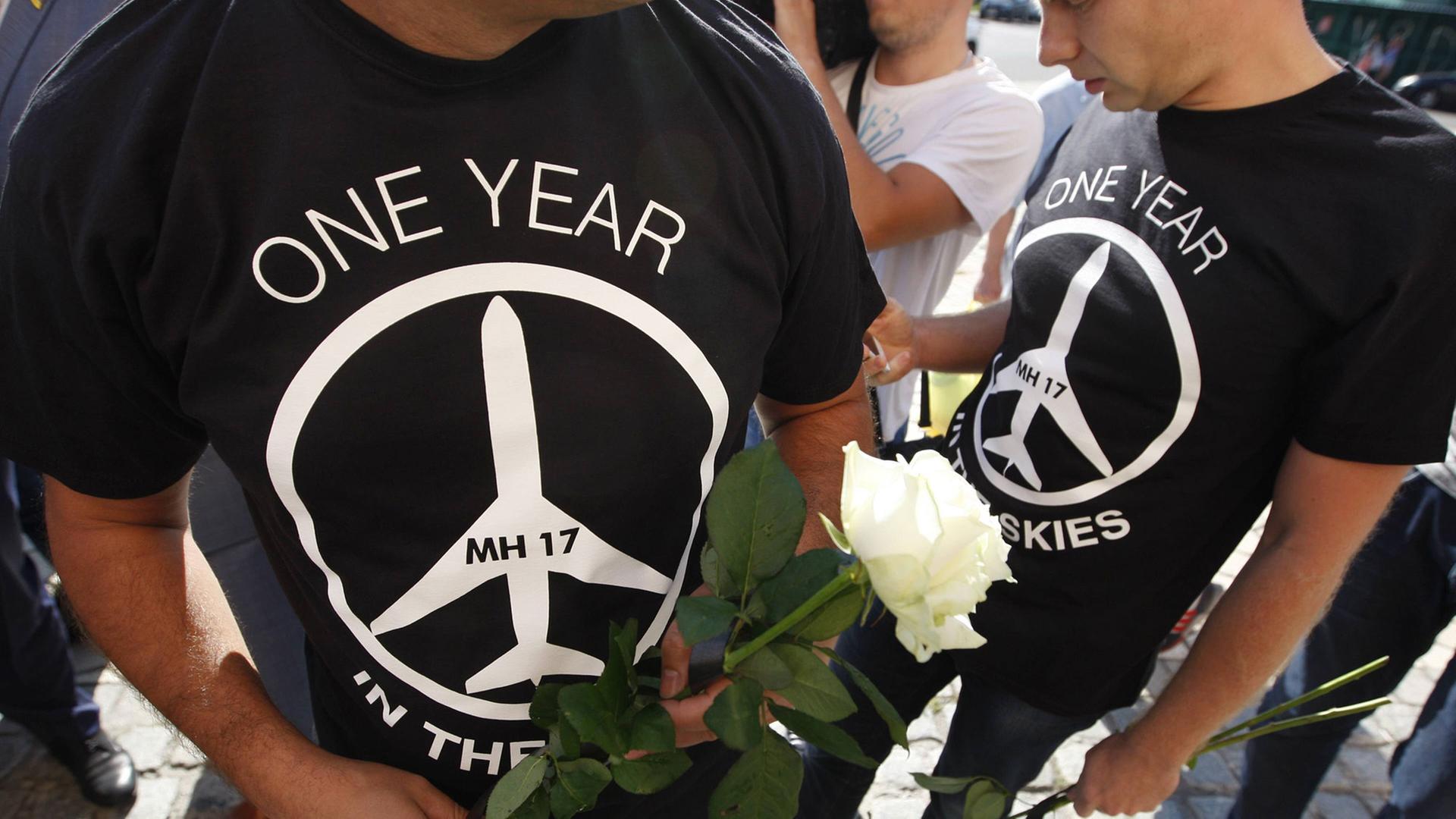 Menschen gedenken ein Jahr nach dem Abschuss der Boeing mit der Flugnummer MH17 über der Ost-Ukraine der Opfer