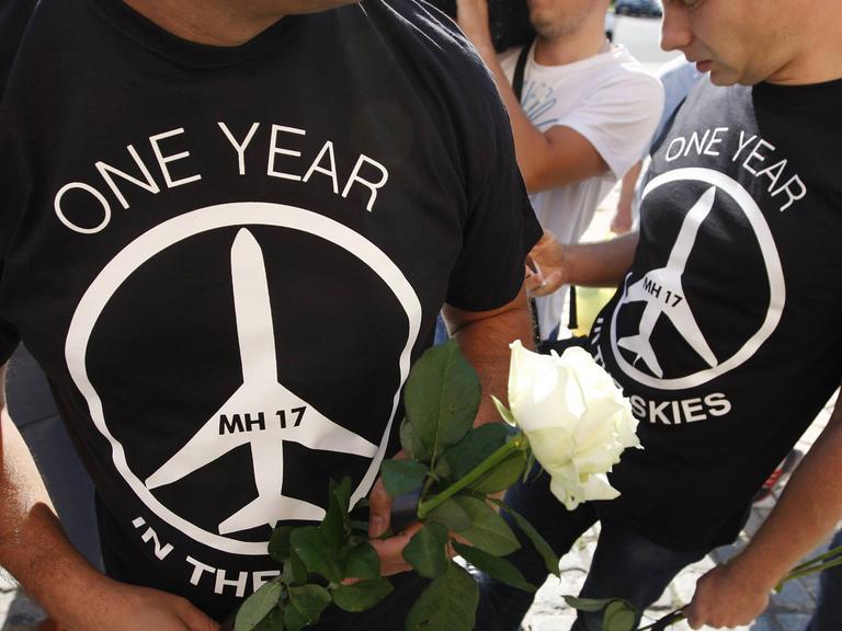 Menschen gedenken ein Jahr nach dem Abschuss der Boeing mit der Flugnummer MH17 über der Ost-Ukraine der Opfer