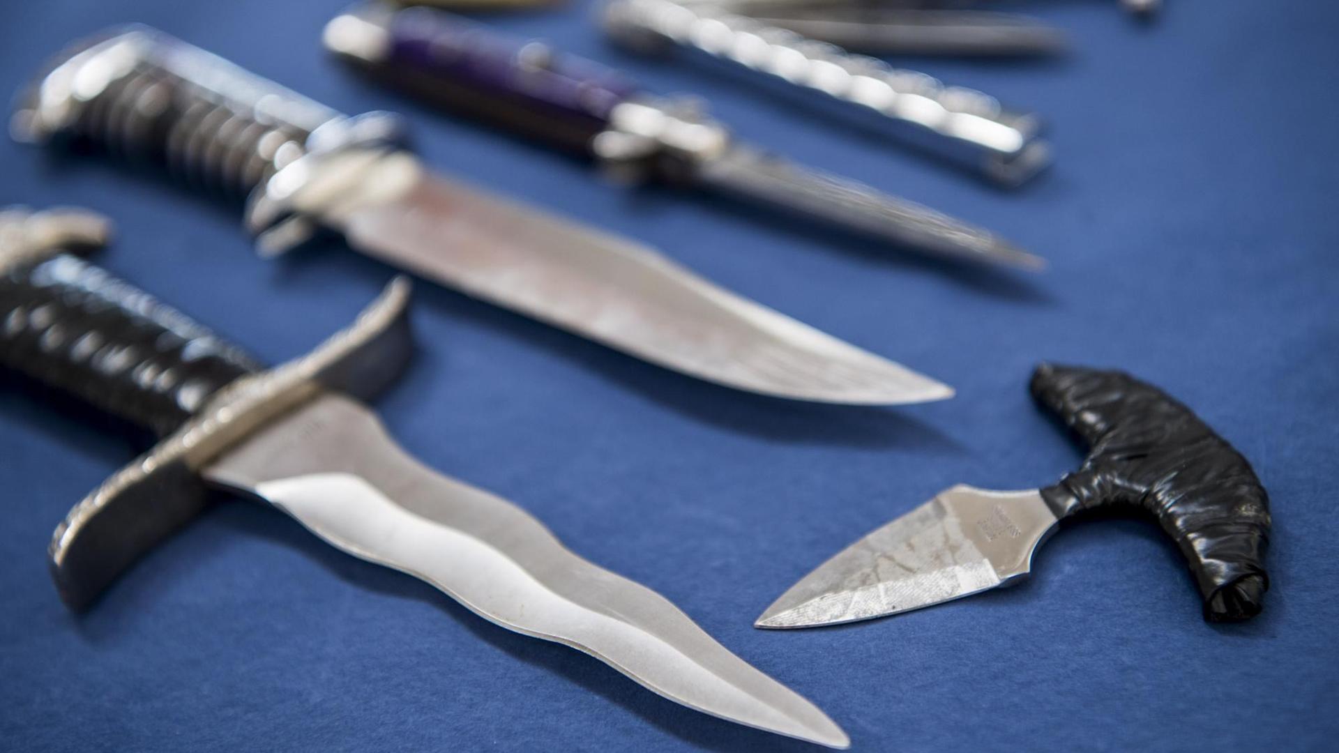 Mehrere Messer mit einer Klingenlänge von mehr als sechs Zentimetern und Faustmesser liegen auf einem Tisch.