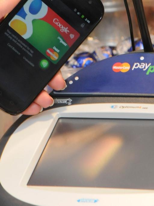 Ein Google-Smartphone wird an einer Supermarkt-Kasse neben ein so genanntes PayPass Gerät zur elektronischen Zahlungsabwicklung gehalten (undatiertes Google-Handout). Statt des dicken Portemonnaies soll bald nur noch ein schlankes Smartphone ausreichen.