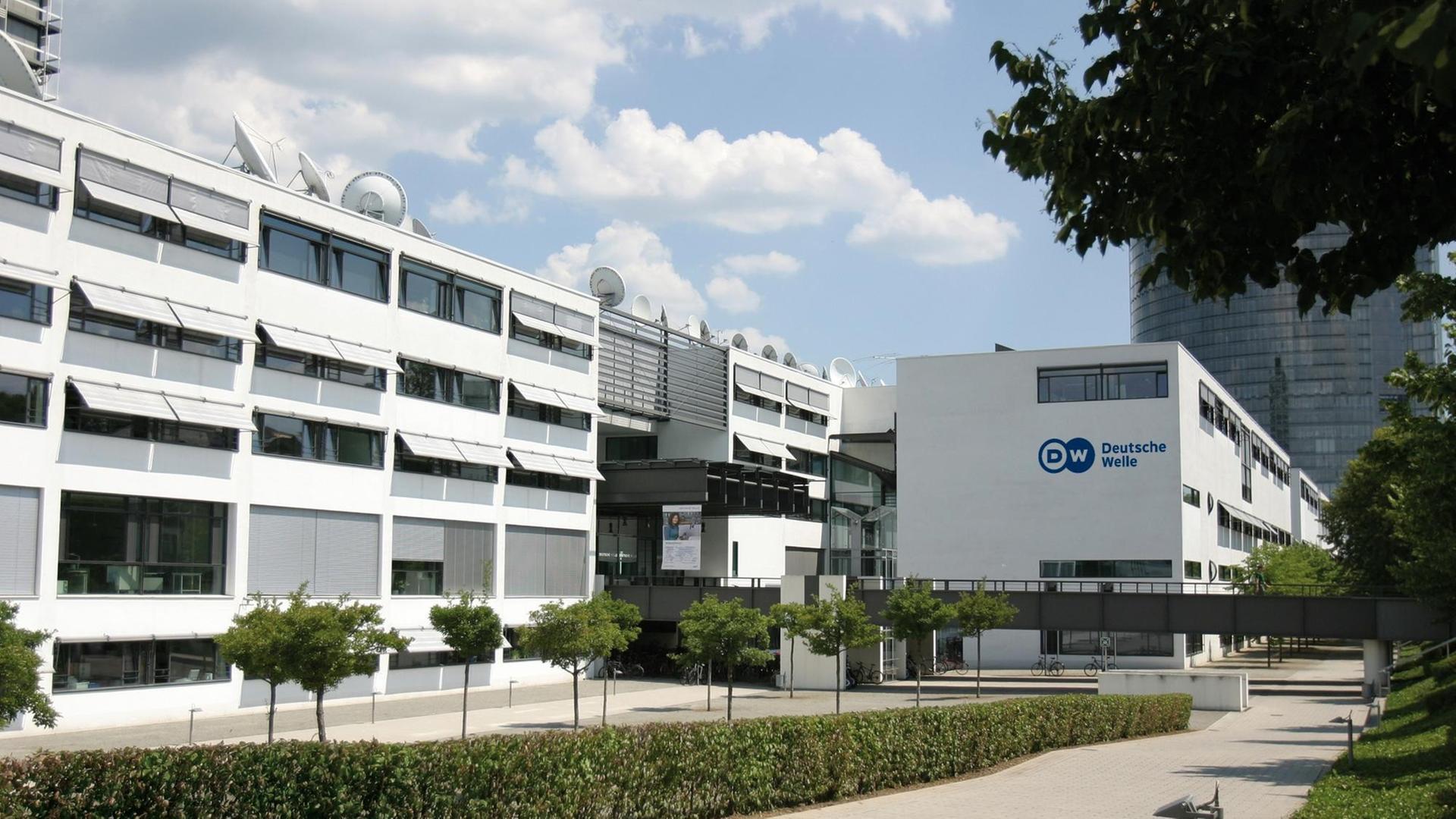 Das langgezogene weiße Gebäude hat mehrere Satelliten-Schüsseln auf dem Dach. Das langgezogene weiße Gebäude hat mehrere Satelliten-Schüsseln auf dem Dach.