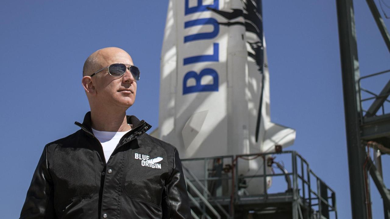 24. November 2015 - Van Horn, Texas, USA - Bezos, Gründer von Blue Origin, inspiziert die Startanlage von New Shepard in West Texas vor dem Jungfernflug der Rakete. Das New Shepard-Raumfahrzeug flog erfolgreich ins All und erreichte eine Höhe von 329.839 Fuß. Das New Shepard-Raumfahrzeug, eine wiederverwendbare suborbitale Rakete und Kapsel, wurde entwickelt, um Passagiere für kurze Ausflüge ins All aus der Erdatmosphäre zu befördern
______

Ein Mann mit Glatze und Sonnenbrille steht vor einer Rakete und schaut in die Ferne.