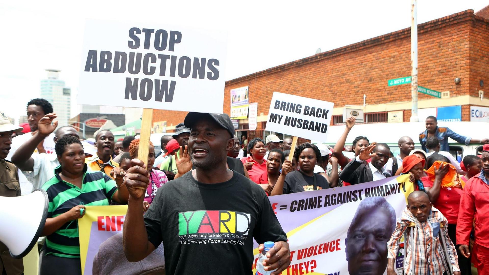 Demonstranten halten in Simbabwe im März 2016 Schilder in die Luft, die eine Aufklärung der Entführung des Journalisten und Aktivisten Itai Dzamara fordern, der 2015 verschleppt wurde und seitdem verschwunden ist.