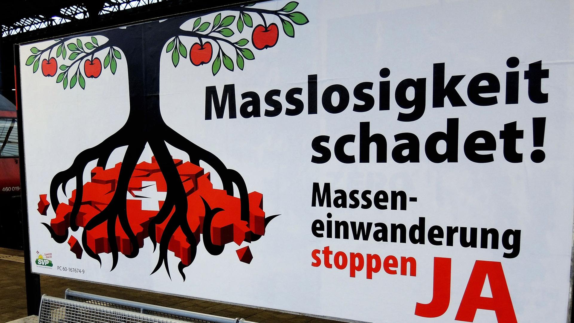 Ein Plakat der Schweizerischen Volkspartei (SVP) gegen "Masseneinwanderung" steht auf dem Bahnhof SBB in Basel. 