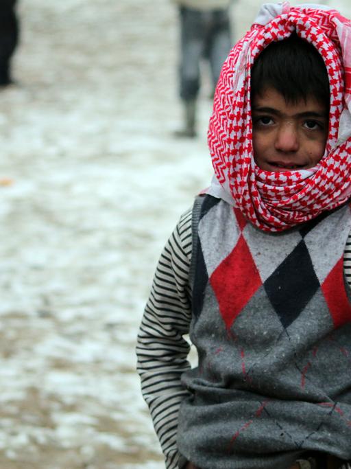 Ein Junge spielt in der syrischen Stadt Aleppo im Schnee.