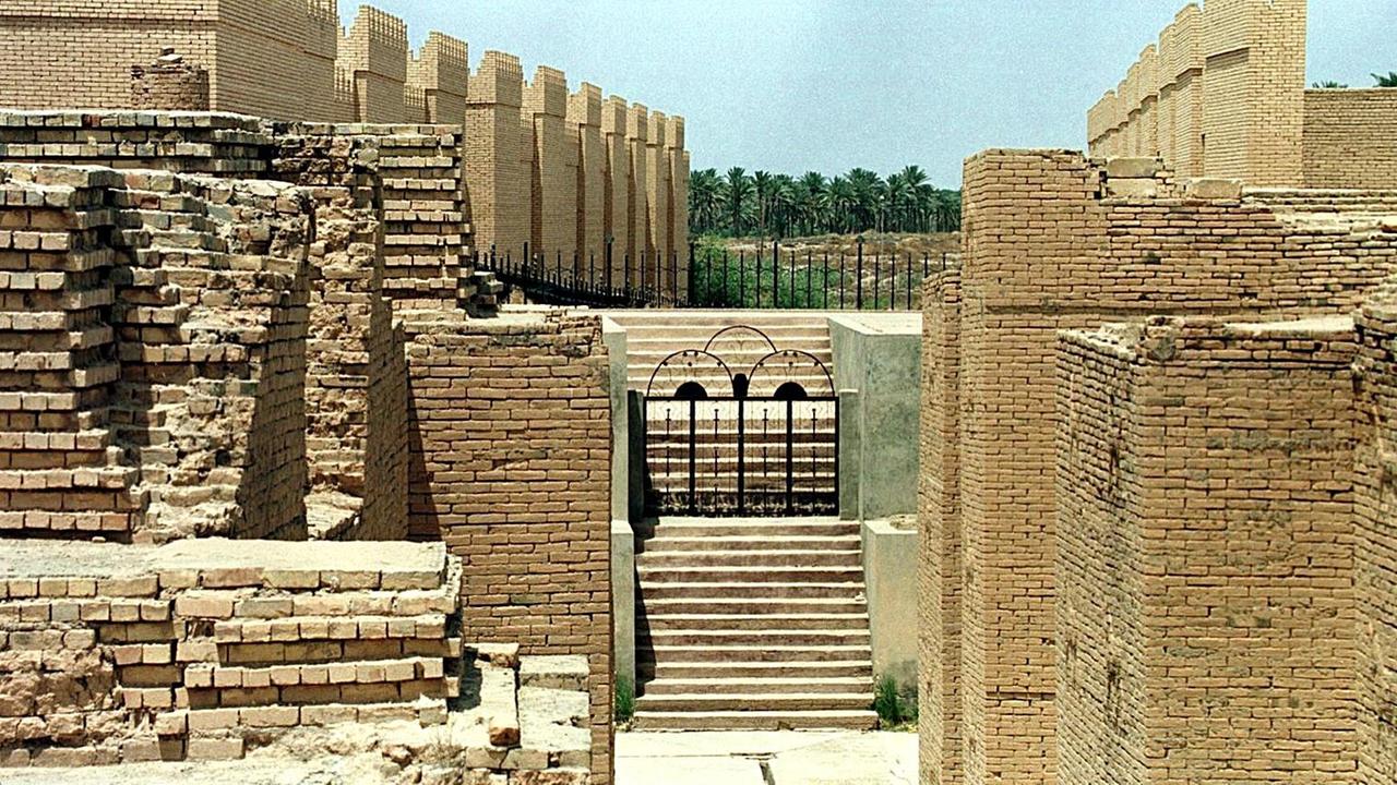 Ruinen der antiken Stadt Bablyon. Im Hintergrund sind die Mauern schon restauriert, vorne noch zerfallen.