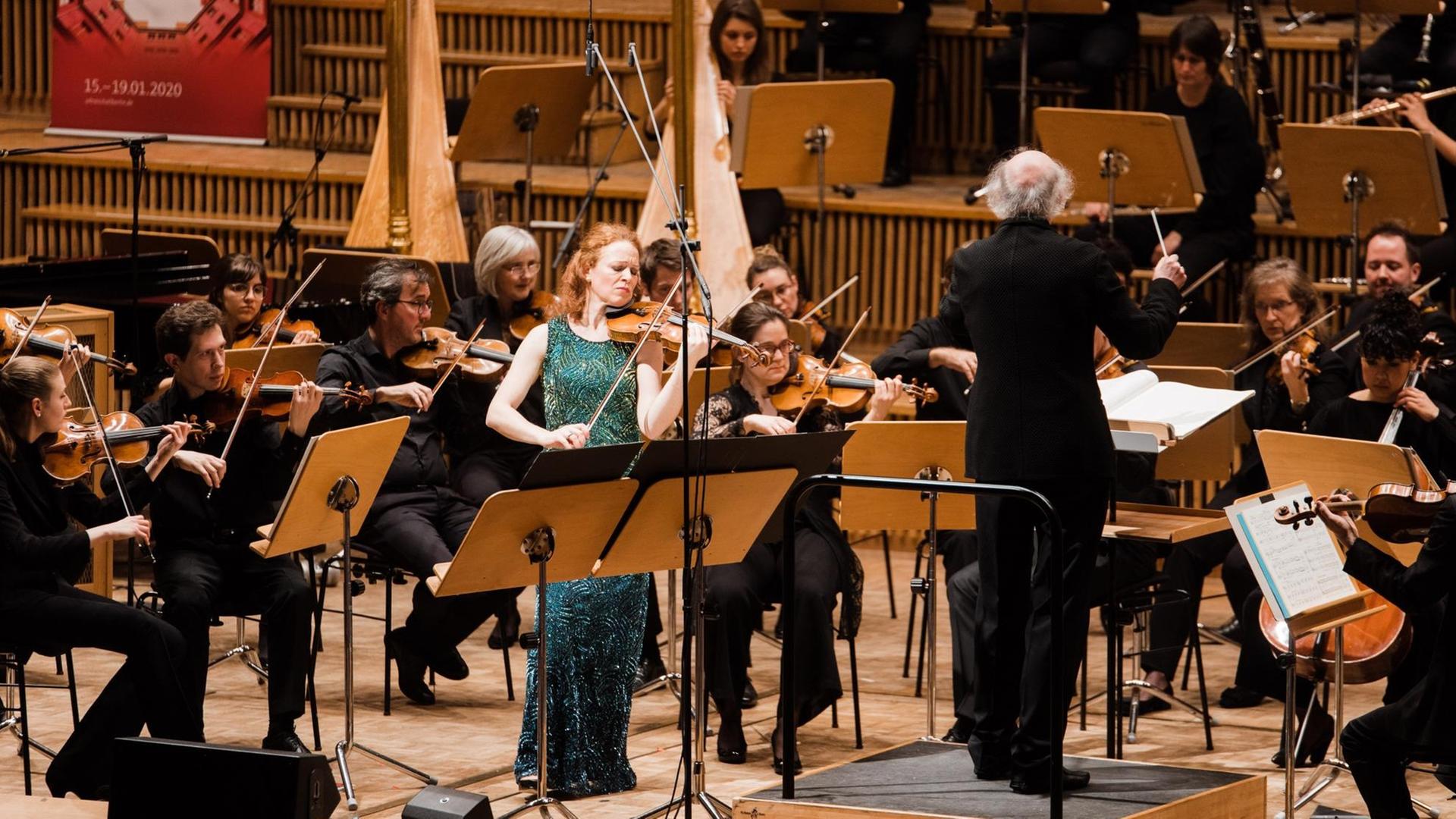 Die Geigerin steht neben dem Dirigenten nahe des Orchesters. (Quelle: Ultraschall Berlin)