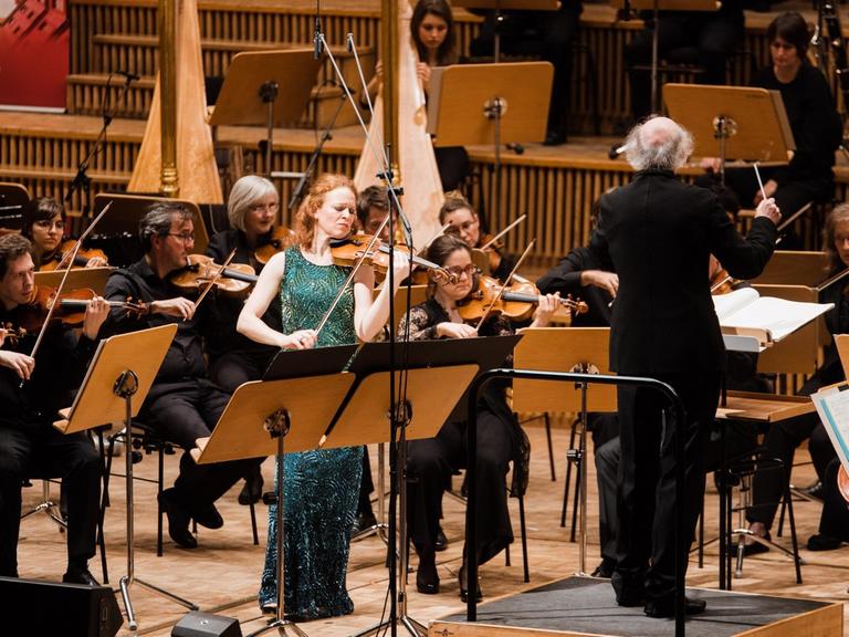 Die Geigerin steht neben dem Dirigenten nahe des Orchesters. (Quelle: Ultraschall Berlin)