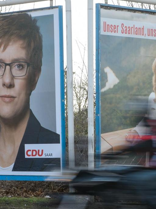 Mit zwei großen Plakaten werben am Annegret Kramp-Karrenbauer (CDU, l) und Anke Rehlinger (SPD) in Saarbrücken (Saarland) um Wählerstimmen.