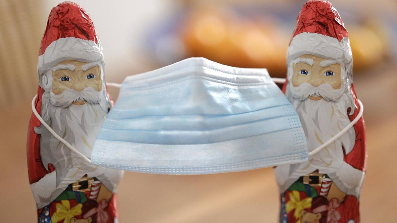 Zwei Weihnachtsmaenner mit einer Nasen-Mund-Schutzmaske, DEU, Berlin, 07.11.2020 *** Two Santa Clauses with one nose and mouth protective mask, DEU, Berlin, 07 11 2020