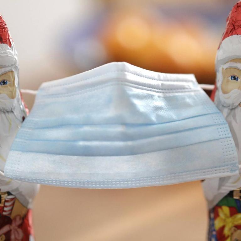 Zwei Weihnachtsmänner mit einer Nasen-Mund-Schutzmaske
