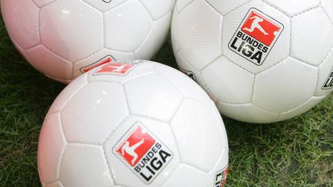 Fußbälle mit dem DFL-Logo (Deutsche Fußball Liga ) liegen auf dem Rasen.