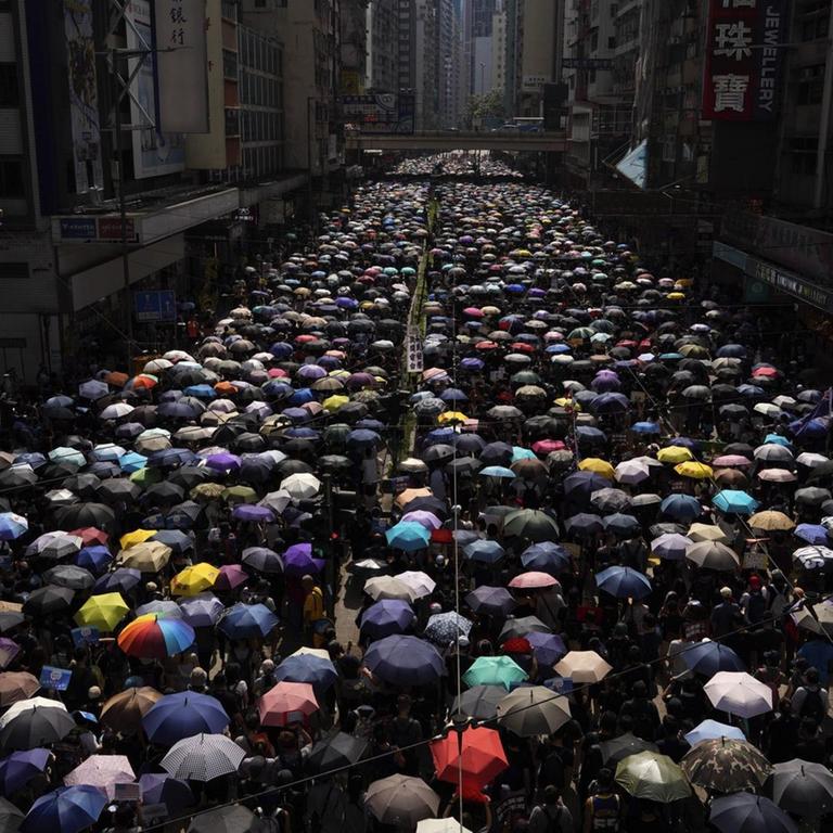 Demonstranten, die Regenschirme tragen, ziehen bei einer Anti-Regierungs-Demonstration 
