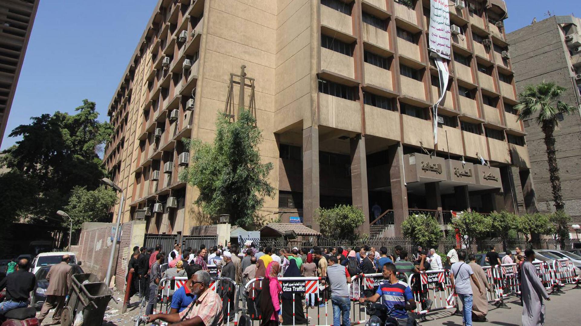 Menschen bilden vor einem Gerichtsgebäude in Kairo eine Warteschlange.