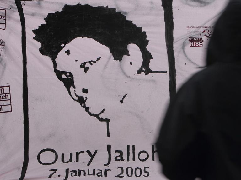 Transparent mit einem Porträt von Oury Jalloh am 13.12.2012 nach der Urteilsverkündung im Prozess um den Feuertod des Afrikaners vor dem Landgericht in Magdeburg (Sachsen-Anhalt). Der Asylbewerber aus Sierra Leone war 2005 in Dessau-Roßlau bei einem Brand in einer Polizeizelle ums Leben gekommen.