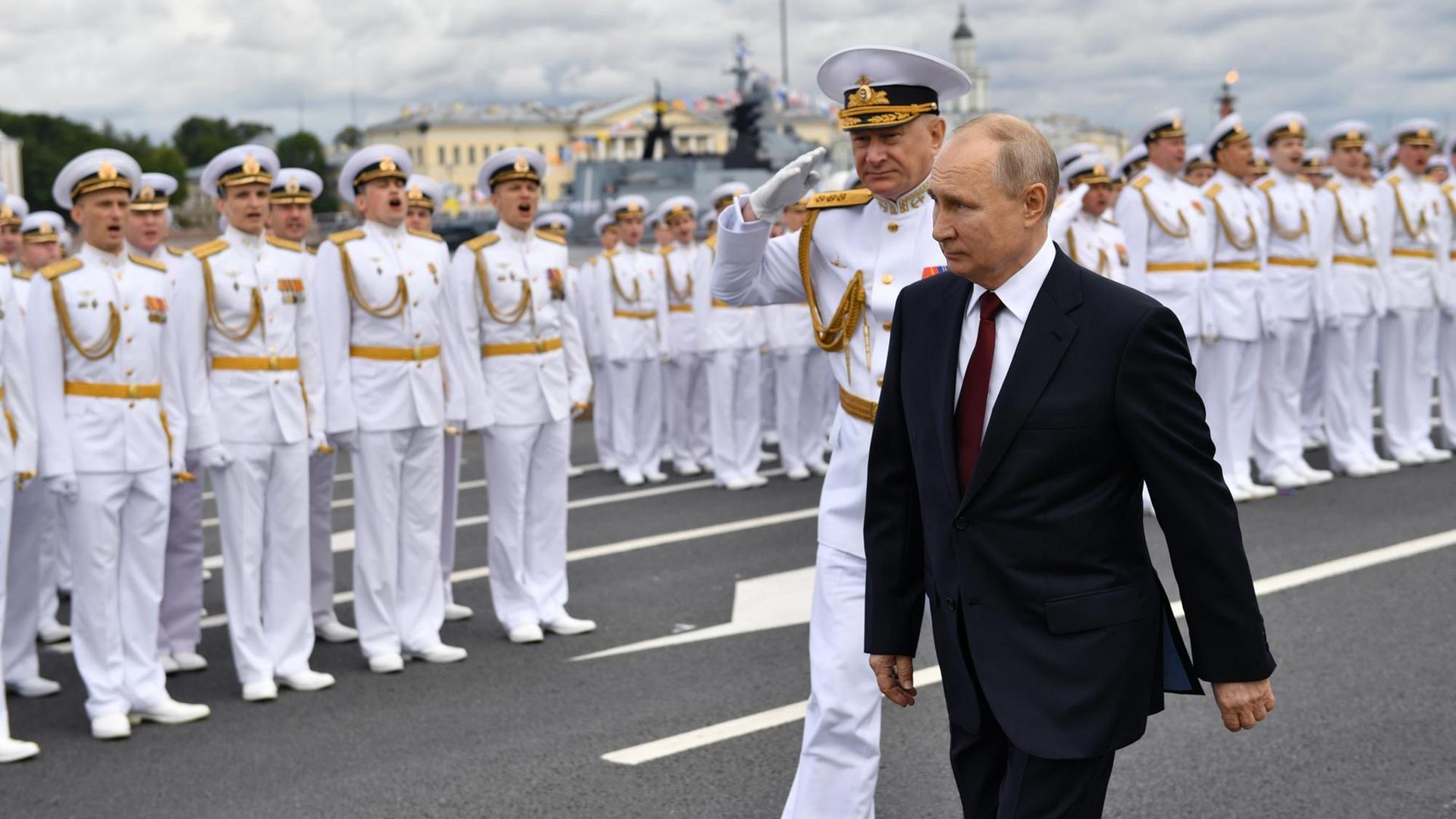 Wladimir Putin, Präsident von Russland, und Admiral Nikolai Jewmenow, Oberbefehlshaber der russischen Marine, schreiten eine Parade von Soldaten ab. Wladimir Putin, Präsident von Russland, und Admiral Nikolai Jewmenow, Oberbefehlshaber der russischen Marine, schreiten eine Parade von Soldaten ab.