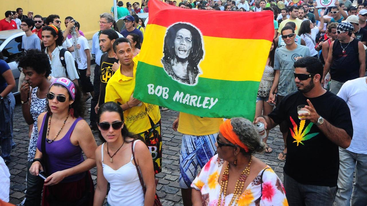 Demonstranten halten eine Fahne mit dem Gesicht des jamaikanischen Sängers Bob Marley hoch. Das ist eine Demonstration für die Legalisierung von Marihuana in Brasilien