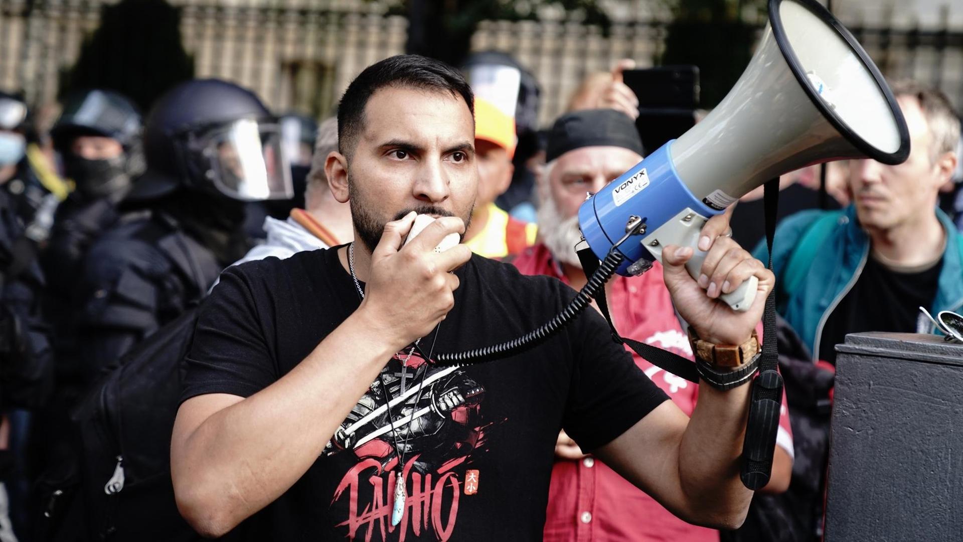 Attila Hildmann spricht vor der russischen Botschaft in Berlin bei einer Demonstration in ein Megaphon