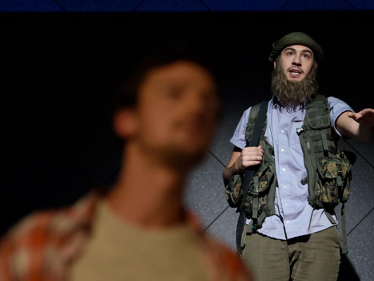 Davide Brizzi (r, als IS-Kämpfer) und Patrik Cieslik (vorn als Frederic Todenhöfer) stehen am 10.10.2016 bei der Fotoprobe des Theaterstücks "Inside IS" im Grips-Theater in Berlin auf der Bühne.