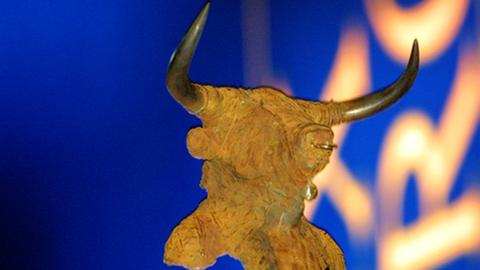 Eine Stierfigur aus Stein vor dem Hintergrund des nicht ganz lesbaren Schriftzugs Prix Europe