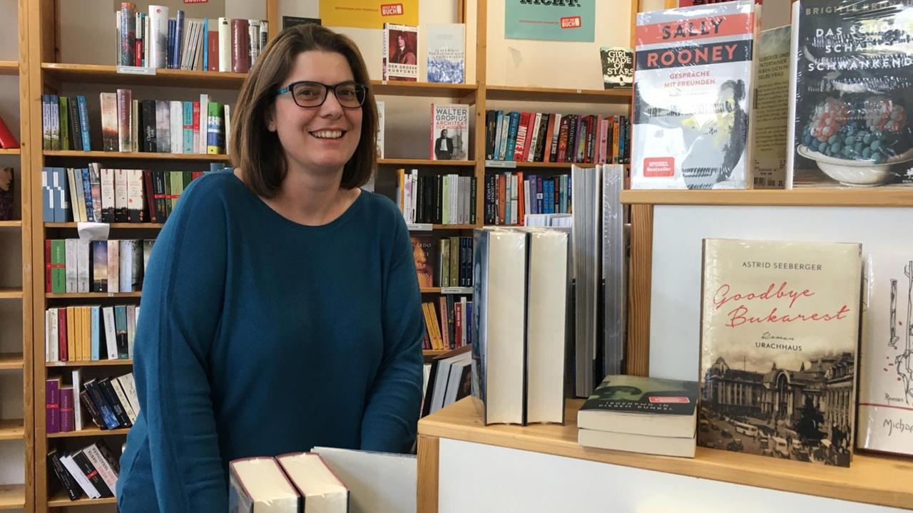 Buchhändlerin Katrin Schmidt steht vor einem Bücherregal in ihrem Geschäft.