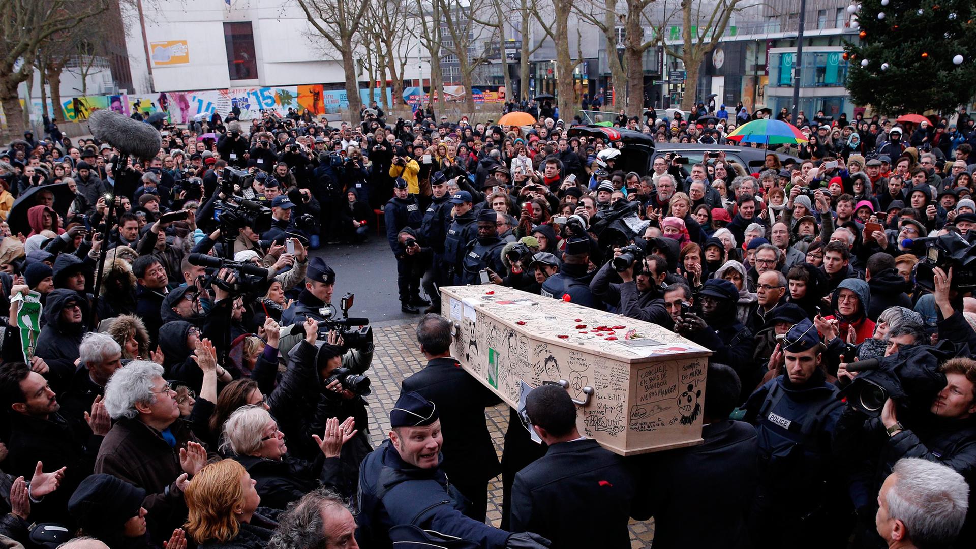 Der Sarg des "Charlie Hebdo"-Zeichners Tignous wird aus dem Rathaus von Montreuil getragen.