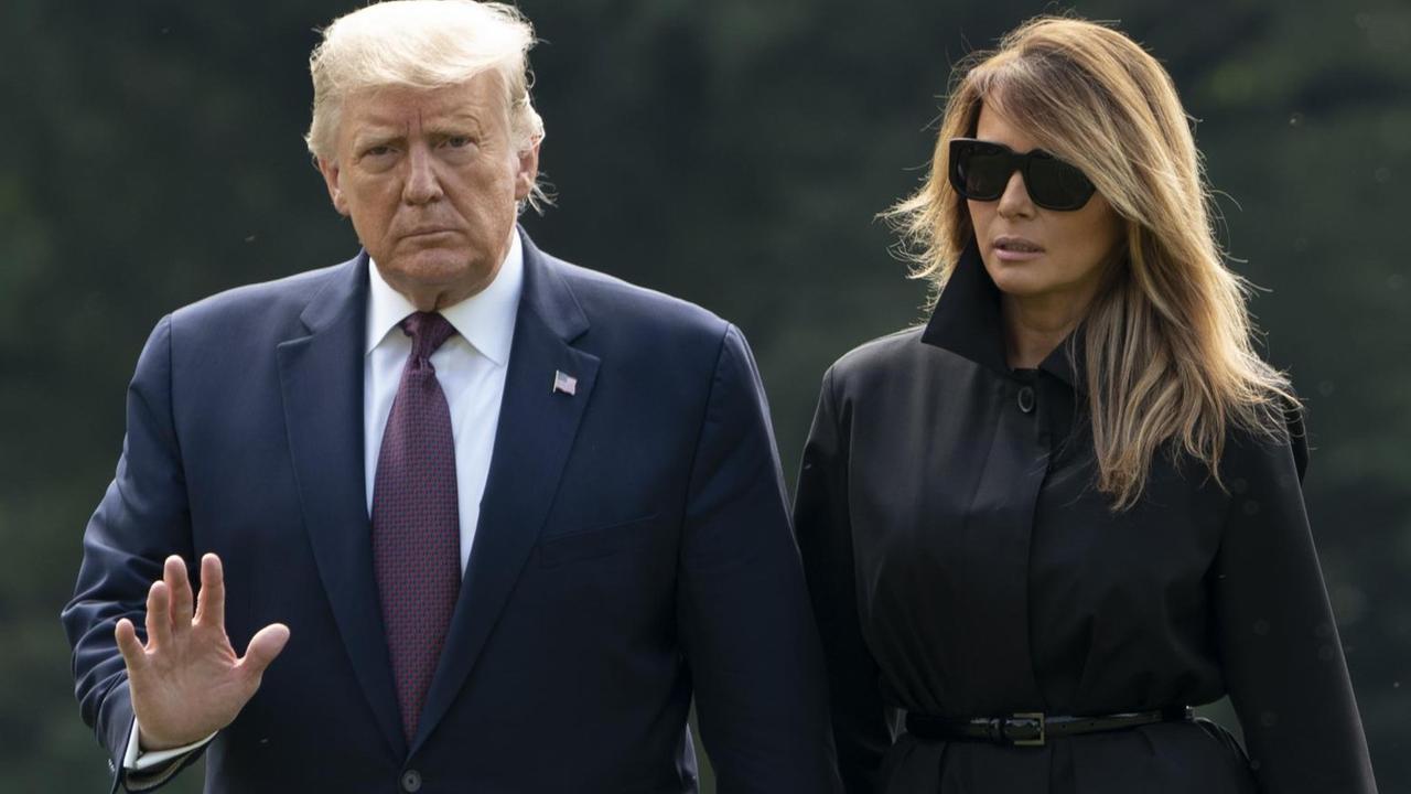 US-Präsident Donald Trump und First Lady Melania Trump laufen über eine Wiese