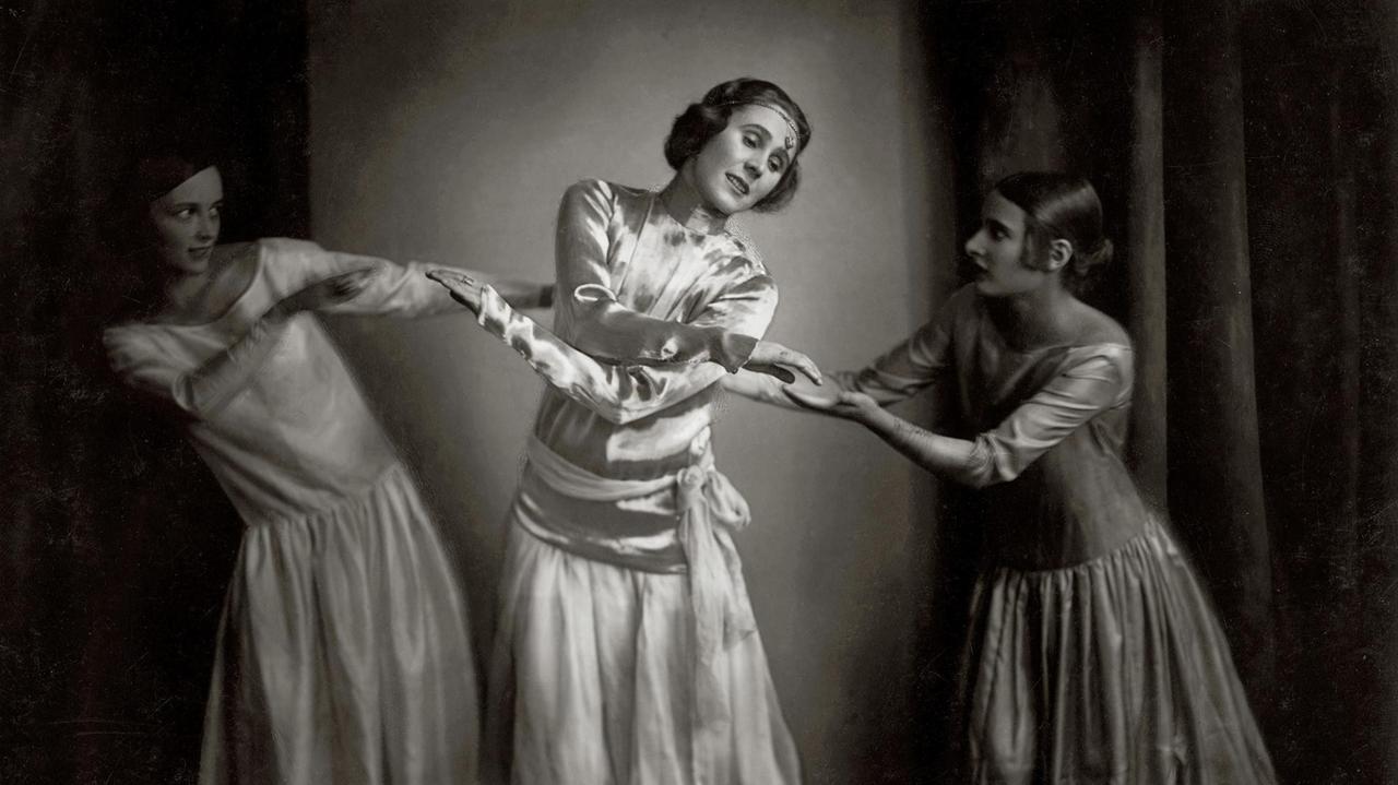 Grete Wiesenthal steht in weiten weißen Gewändern ziwschen zwei weiteren Tänzerinnen.