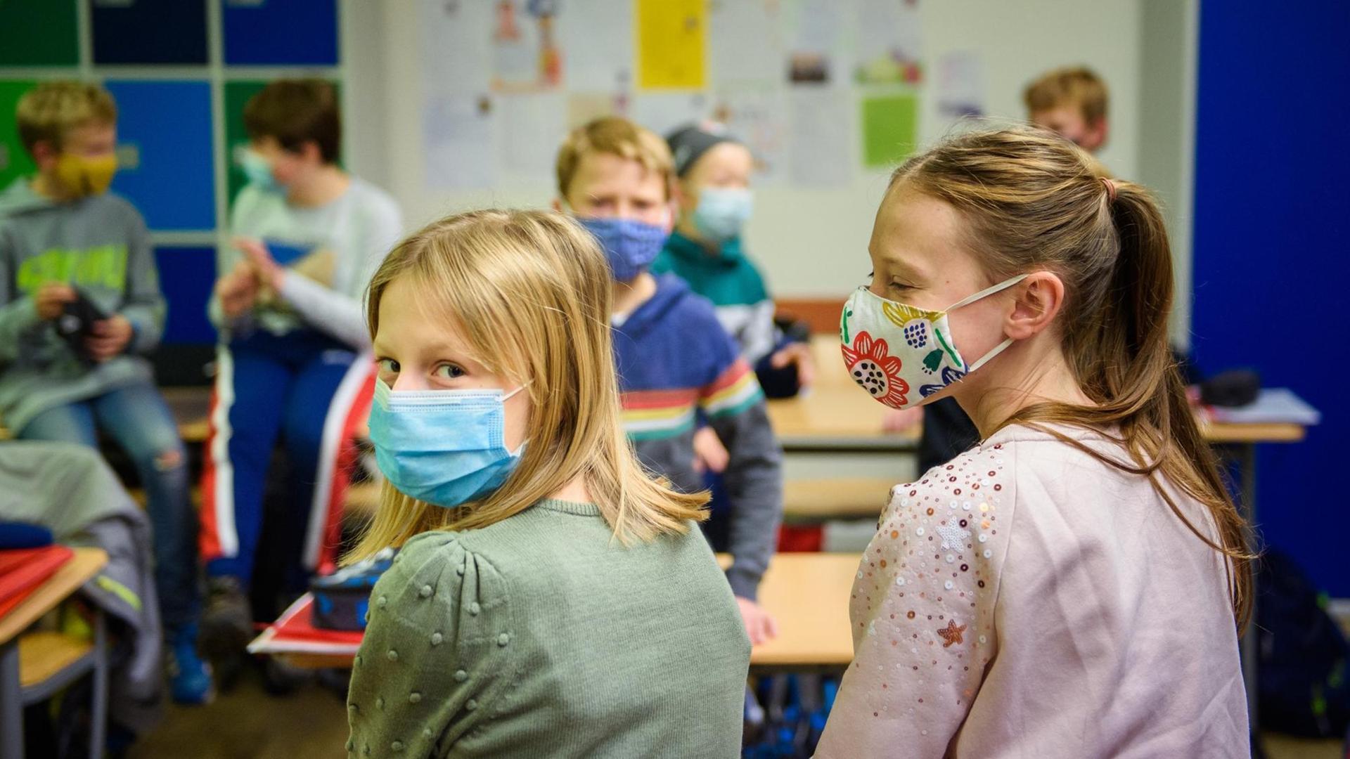 Schülerinnen und Schüler einer sechsten Klasse der Max-Planck-Schule Kiel warten in ihrem Klassenzimmer auf den Unterrichtsbeginn nach den Herbstferien und tragen dabei einen Mund-Nasen-Schutz.