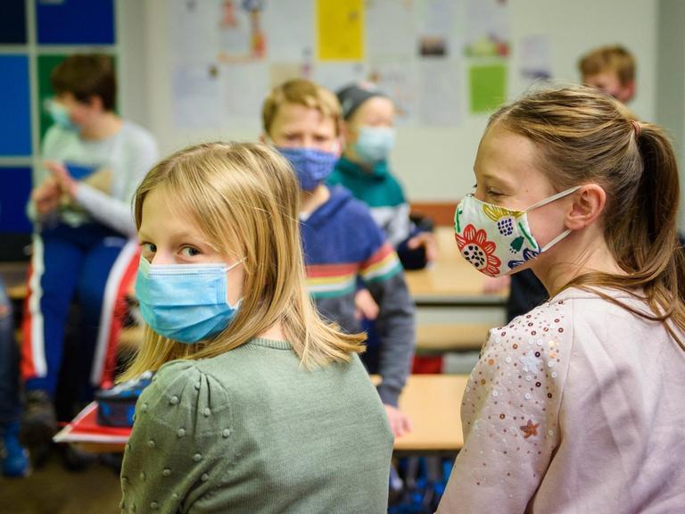 Schülerinnen und Schüler einer sechsten Klasse der Max-Planck-Schule Kiel warten in ihrem Klassenzimmer auf den Unterrichtsbeginn nach den Herbstferien und tragen dabei einen Mund-Nasen-Schutz.