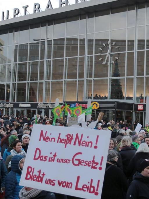 Hunderte Menschen haben sich in Köln vor dem Hauptbahnhof versammelt. Sie tragen Plakate mit Aufschriften wie "Nein heißt nein! Das ist unser Gesetz!"