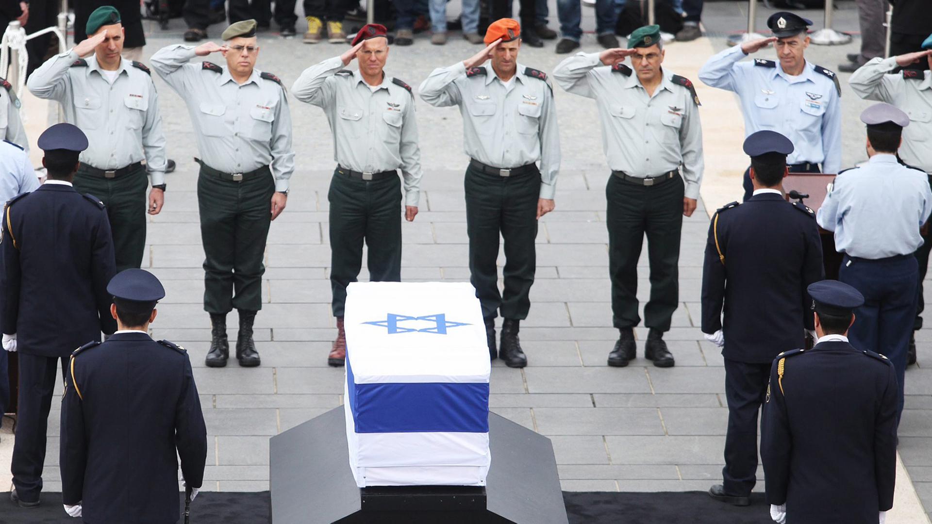 Offiziere der israelische Armee salutieren am Sarg von Ariel Scharon. Der Sarg ist in eine israelische Flagge eingewickelt. Offiziere der israelische Armee salutieren am Sarg von Ariel Scharon. Der Sarg ist in eine israelische Flagge eingewickelt.