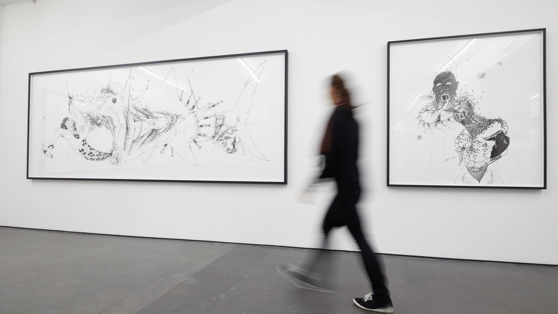 Eine Frau geht in einer Ausstellung in den Deichtorhallen Hamburgan zwei Bildern vorbei. Eine Frau geht in einer Ausstellung in den Deichtorhallen Hamburgan zwei Bildern vorbei.