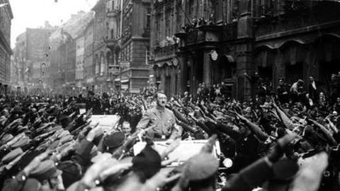 Adolf Hitler wird 1933 jubelnd  in München begrüßt.