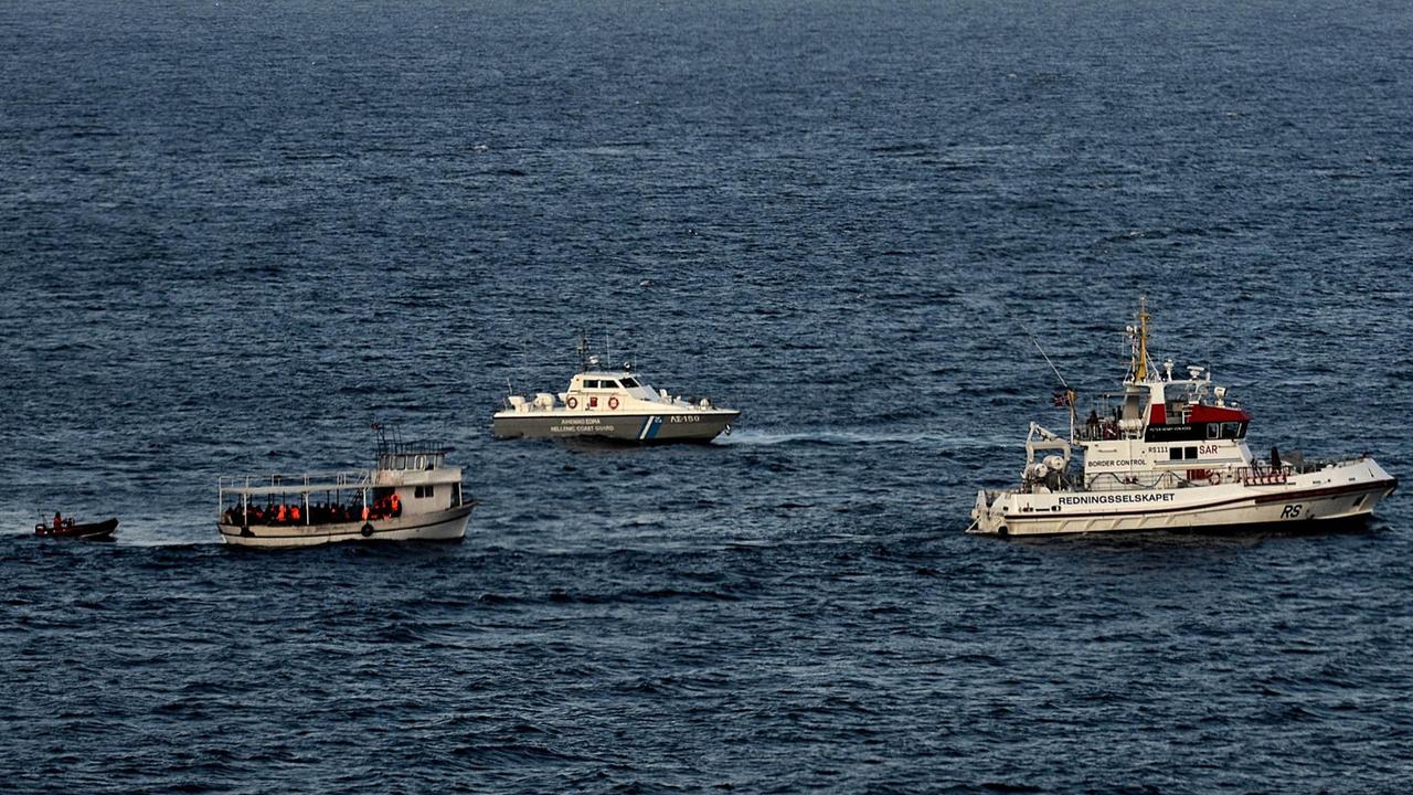 Ein Flüchtlingsboot an der griechischen Küste vor Lesbos wird von der griechischen Küstenwache und Frontex eskortiert.