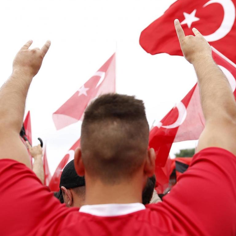 Ein Teilnehmer der Erdogan-Großkundgebung anlässlich des gescheiterten Putschversuchs in der Türkei mit ca. 20.000 Erdogan-Anhängern in der Deutzer Werft in Köln reißt die Arme hoch