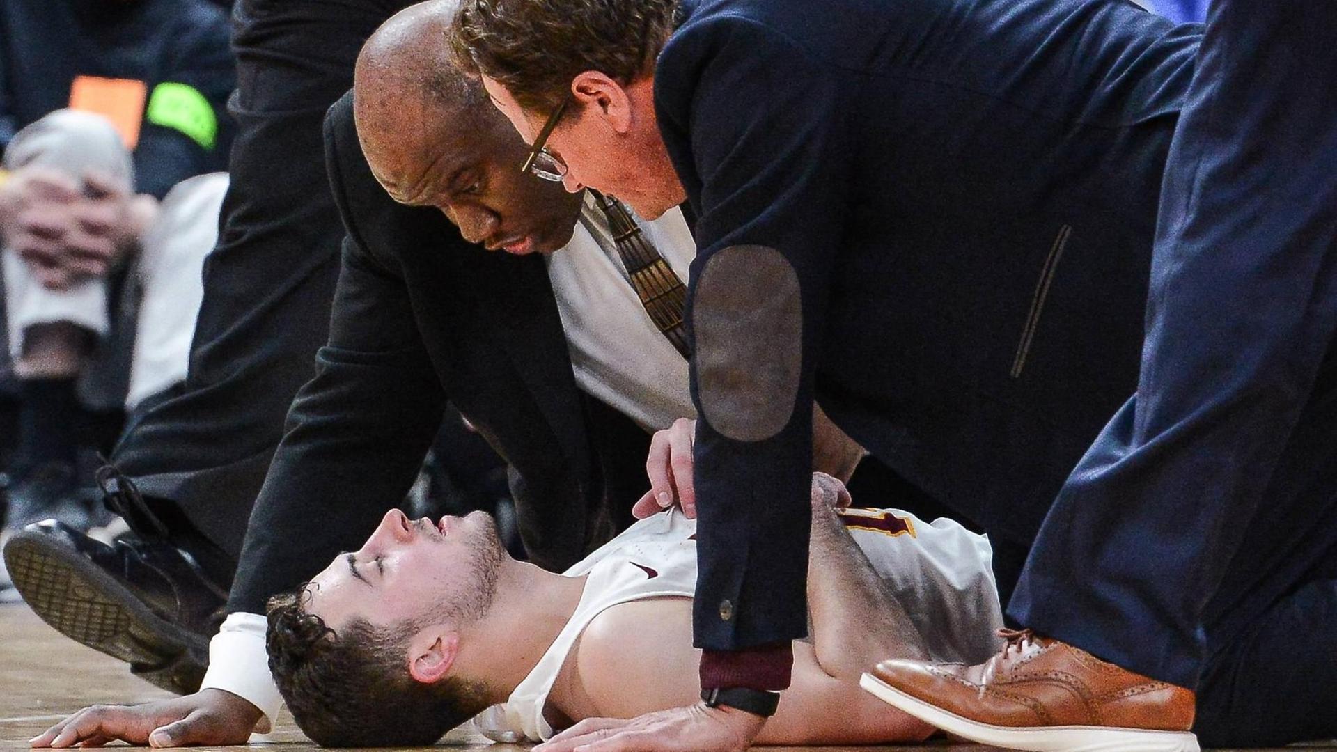 Die Trainer des College-Basketballer Ben Richardson von der Loyola University Chicago reden vehement auf ihren verletzten Schützling ein.
