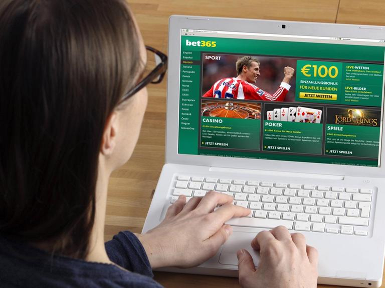 Eine Frau sitzt am Laptop und spielt Sportwetten im Internet (Symbolfoto)