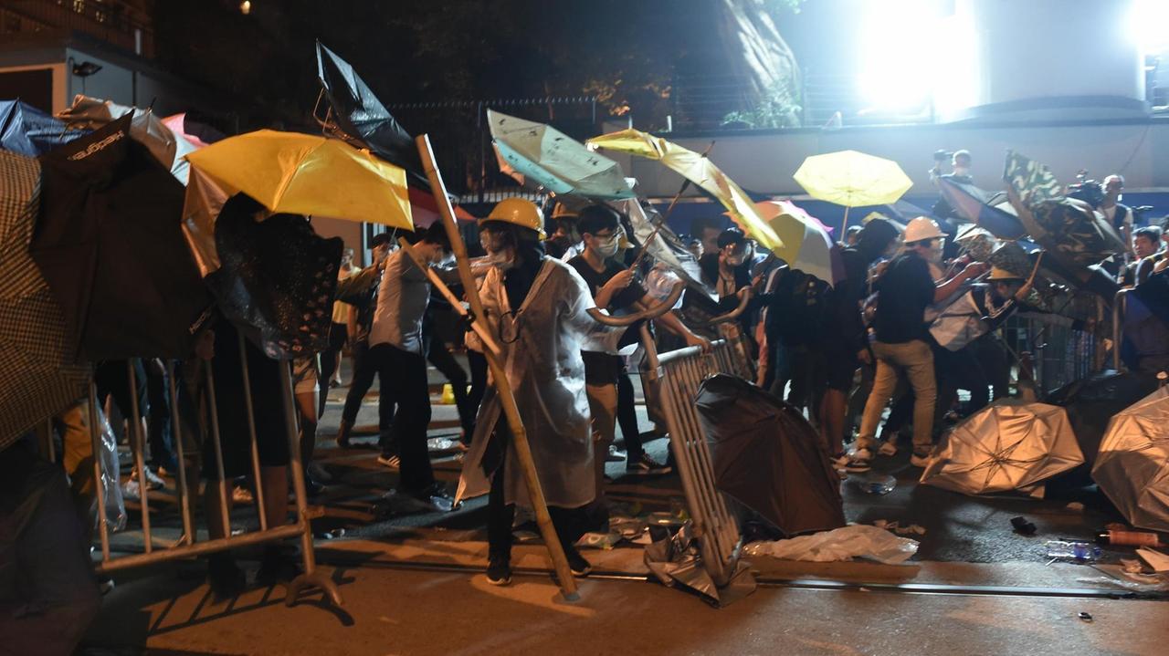 Die Demonstranten haben in Erinnerung an die Proteste von 2014 aufgespannte Regenschirme mit dabei, als sie gegen die Einflussnahme Pekings auf die Straße gehen. 